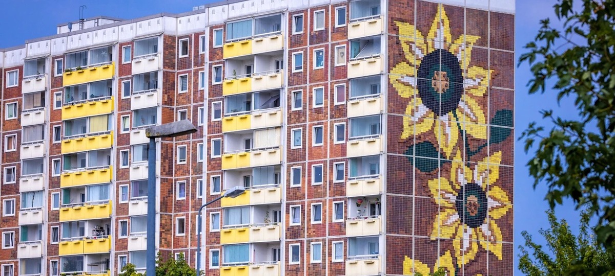 L’immeuble connu sous le nom de Sonnenblumenhaus abritait le centre d’accueil central pour les demandeurs d’asile et un foyer pour les travailleurs contractuels vietnamiens. L’immeuble fait partie du grand ensemble résidentiel à Rostock-Lichtenhagen.